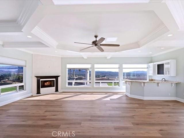 unfurnished living room with hardwood / wood-style floors, crown molding, and beamed ceiling