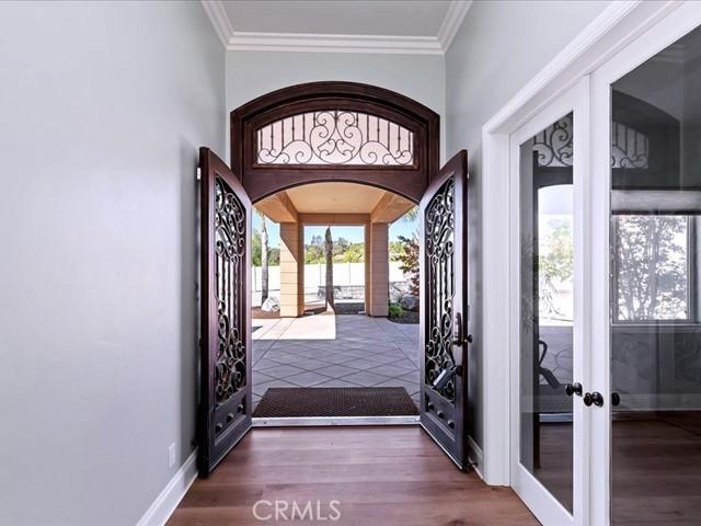 foyer with ornamental molding, dark wood-type flooring, and french doors