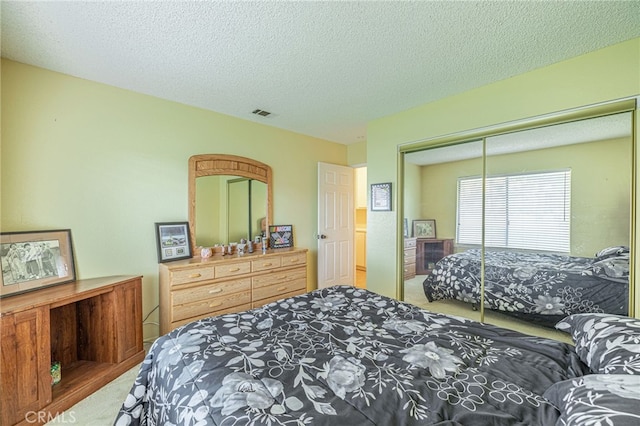 carpeted bedroom with a textured ceiling and a closet