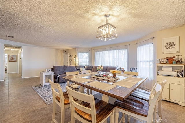 dining area featuring a textured ceiling and an inviting chandelier