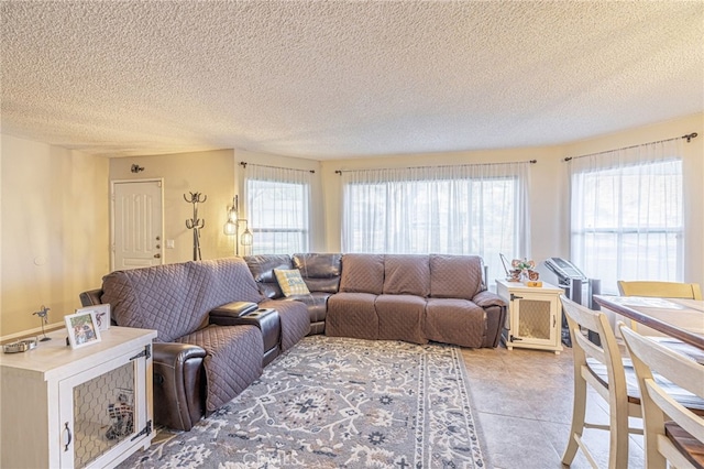 living room featuring a healthy amount of sunlight, light tile patterned floors, and a textured ceiling