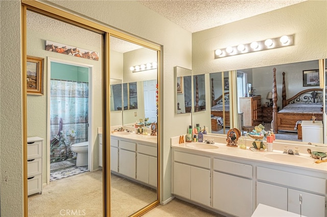 bathroom featuring vanity, toilet, and a textured ceiling