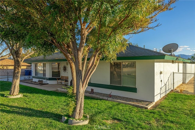 rear view of property with a lawn and a patio area