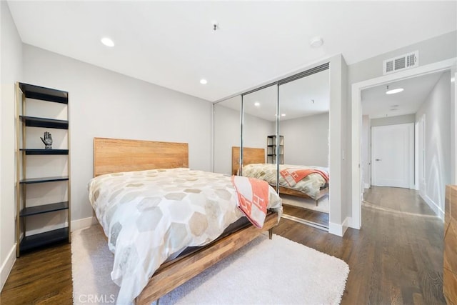 bedroom with a closet and dark wood-type flooring