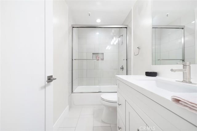 full bathroom featuring shower / bath combination with glass door, tile patterned flooring, vanity, and toilet