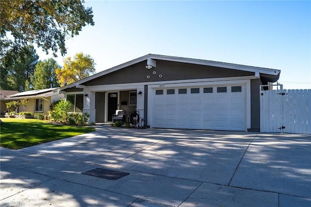 ranch-style home featuring a garage and a front yard