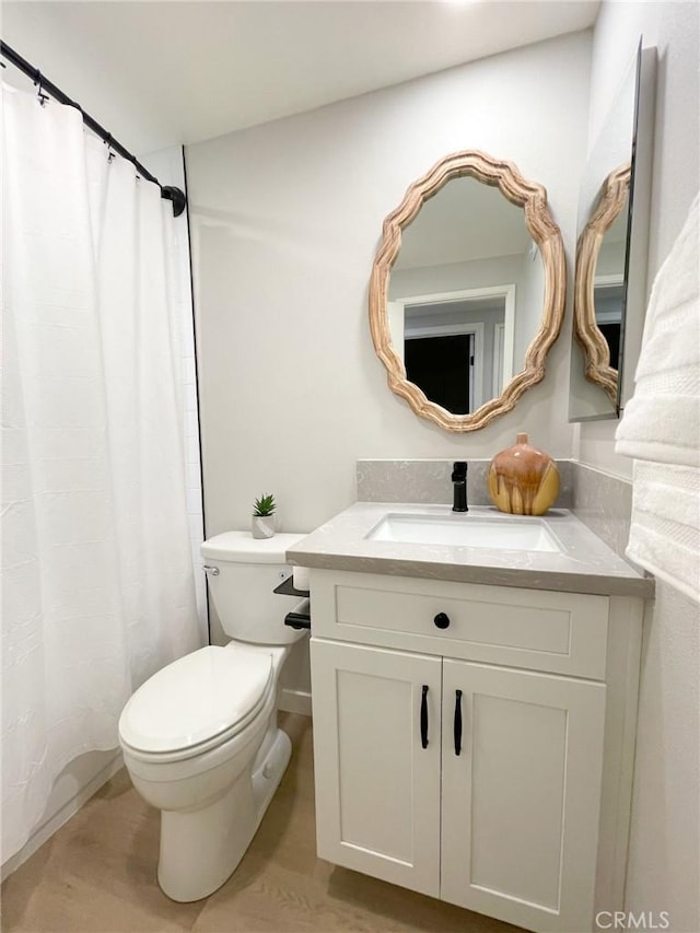 bathroom with vanity, hardwood / wood-style flooring, and toilet