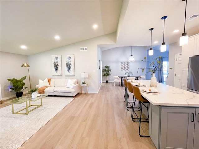 living room with lofted ceiling and light wood-type flooring