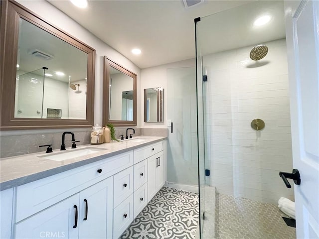 bathroom featuring tile patterned floors, a shower with door, and vanity