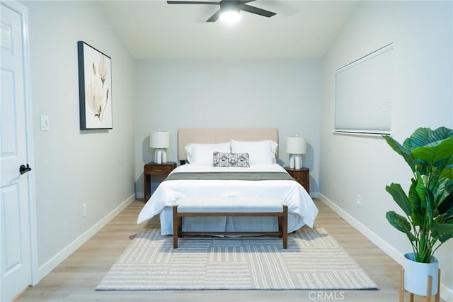 bedroom featuring light hardwood / wood-style floors, vaulted ceiling, and ceiling fan