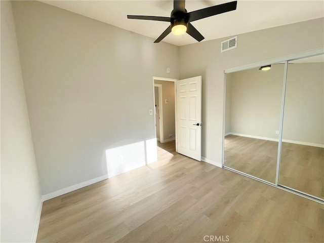 unfurnished bedroom featuring ceiling fan, light wood-type flooring, and a closet