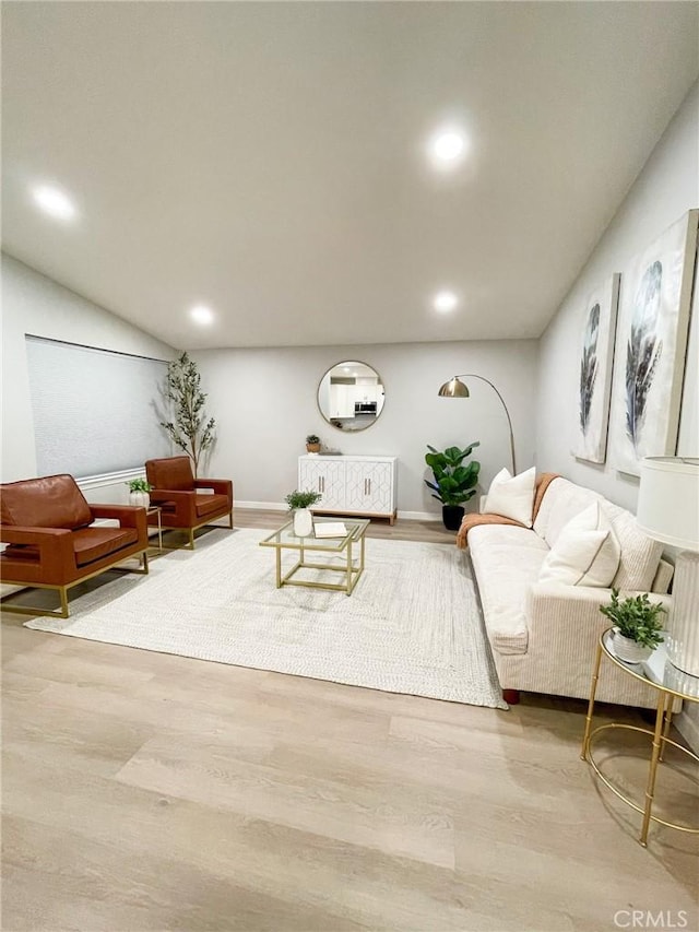 living room with lofted ceiling and light hardwood / wood-style flooring