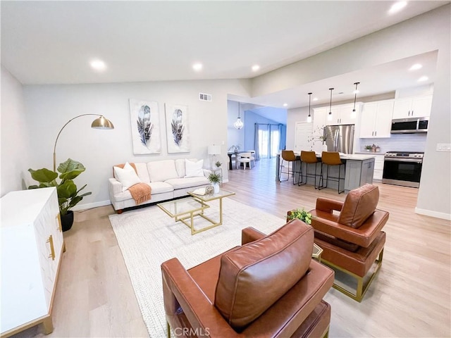 living room featuring light wood-type flooring and lofted ceiling