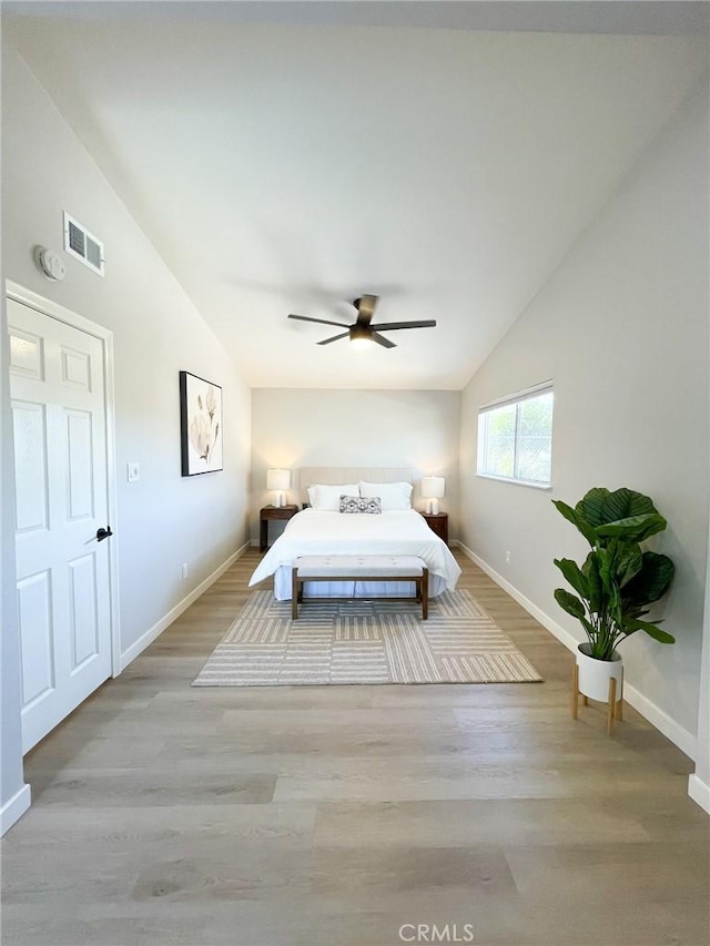 unfurnished bedroom with ceiling fan, light wood-type flooring, and vaulted ceiling