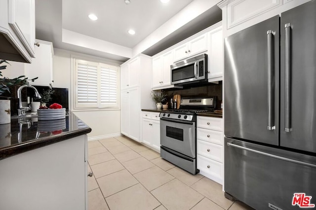 kitchen featuring light tile patterned floors, white cabinets, stainless steel appliances, and tasteful backsplash