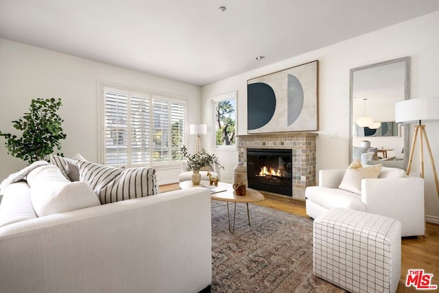 living room featuring a brick fireplace and hardwood / wood-style floors