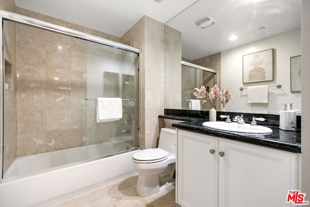 full bathroom with combined bath / shower with glass door, vanity, tile patterned floors, and toilet