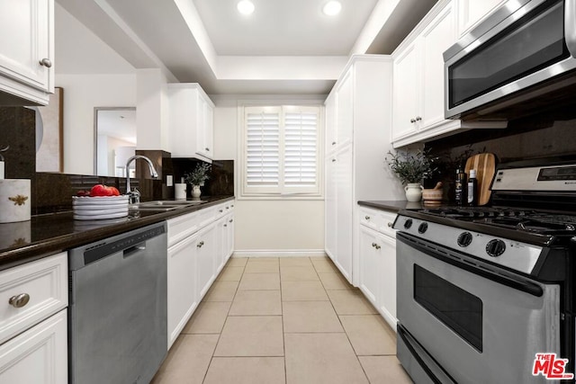 kitchen with sink, white cabinets, stainless steel appliances, and tasteful backsplash