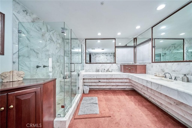 bathroom with vanity, a shower with shower door, and tile walls