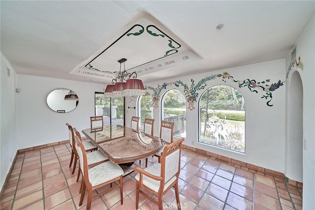 tiled dining space featuring a tray ceiling