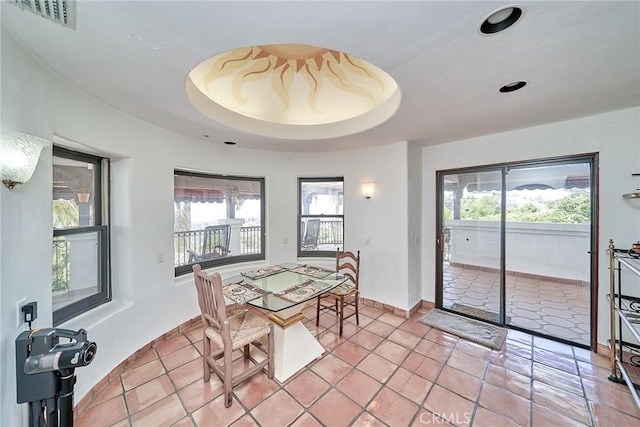 tiled dining room featuring a tray ceiling