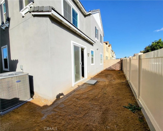 view of side of home with central air condition unit