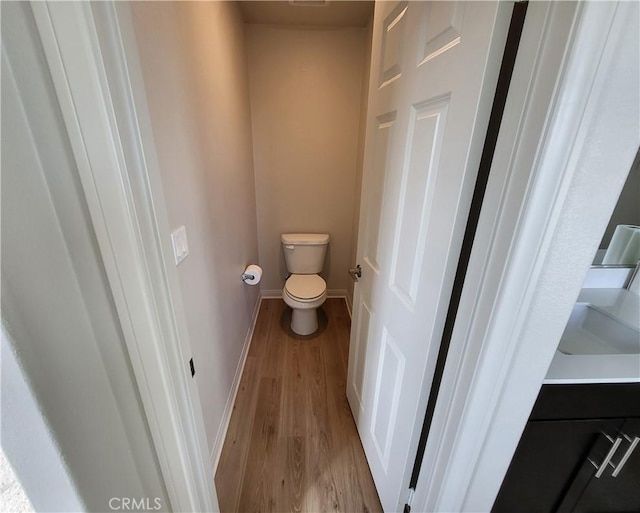 bathroom with hardwood / wood-style floors and toilet