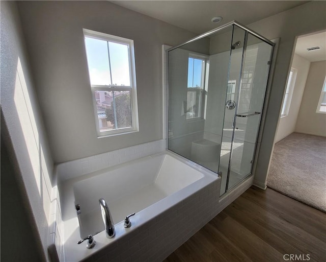 bathroom featuring hardwood / wood-style flooring and plus walk in shower