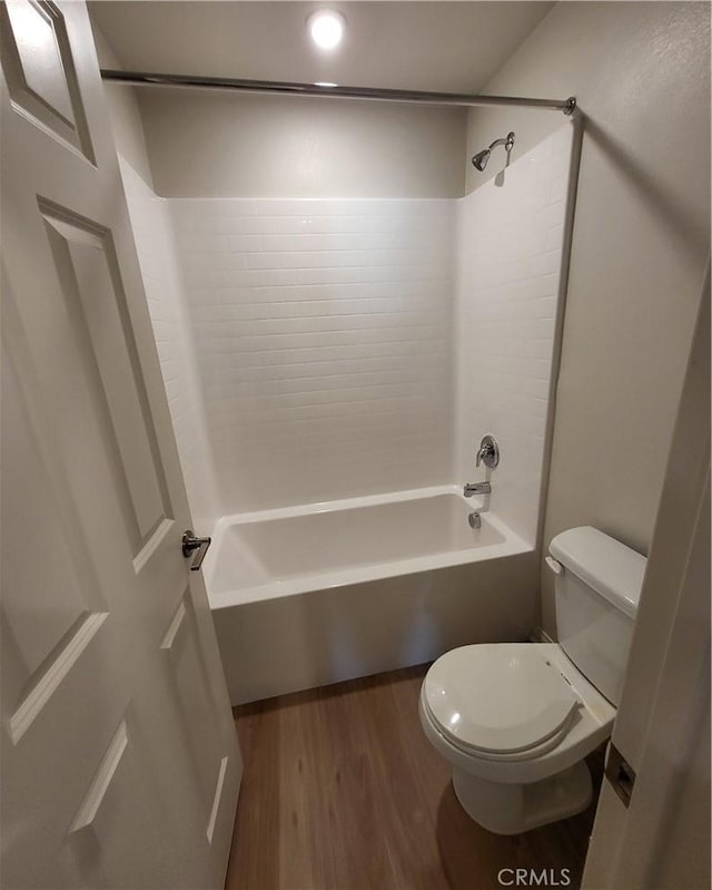 bathroom with hardwood / wood-style floors, shower / bathtub combination, and toilet