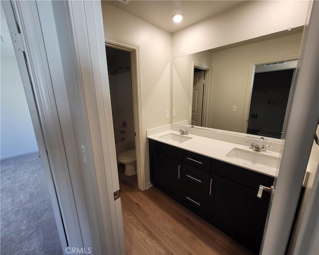 bathroom featuring wood-type flooring, vanity, and toilet