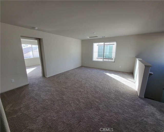 carpeted spare room with a healthy amount of sunlight