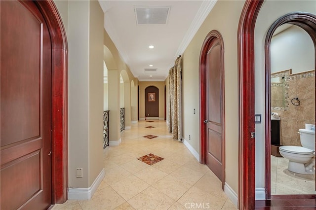 corridor featuring light tile patterned floors and ornamental molding