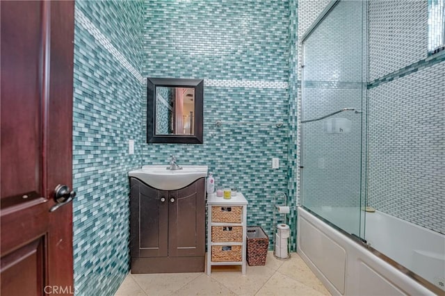 bathroom featuring vanity, tile patterned floors, tile walls, and enclosed tub / shower combo