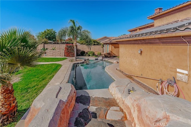 view of swimming pool with a yard