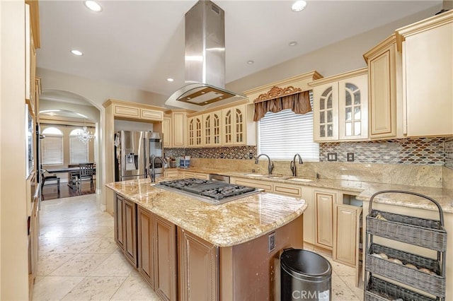 kitchen with a center island, stainless steel appliances, light stone counters, backsplash, and island range hood