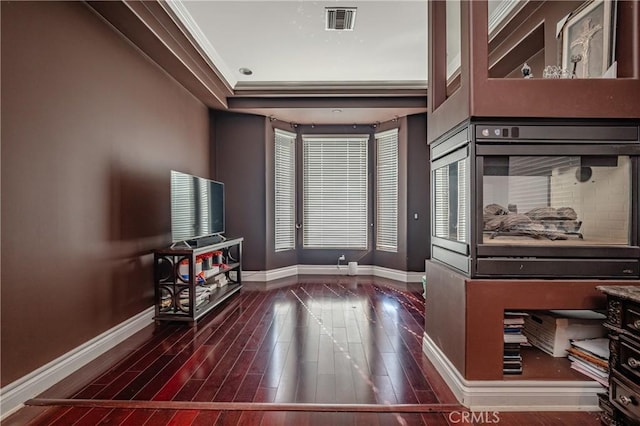 interior space with dark hardwood / wood-style flooring and crown molding