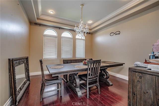 dining area with a raised ceiling, crown molding, and dark hardwood / wood-style floors