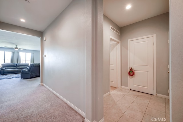 hall with light colored carpet