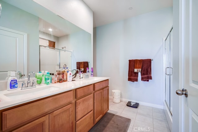 bathroom with tile patterned floors, a shower with door, and vanity