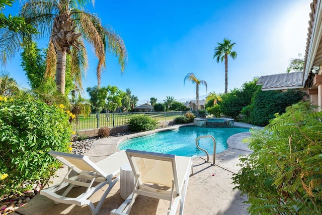 view of swimming pool featuring a patio area and an in ground hot tub