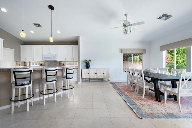 kitchen with light stone countertops, backsplash, ceiling fan, decorative light fixtures, and white cabinets