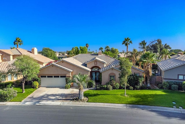 mediterranean / spanish house with a garage and a front lawn