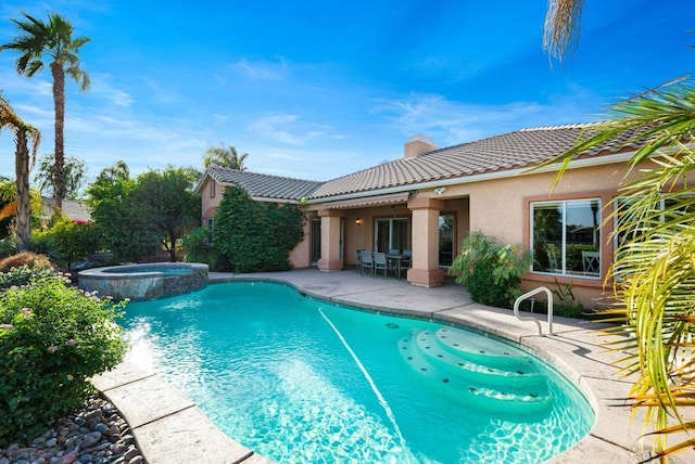 view of pool with a patio area and an in ground hot tub