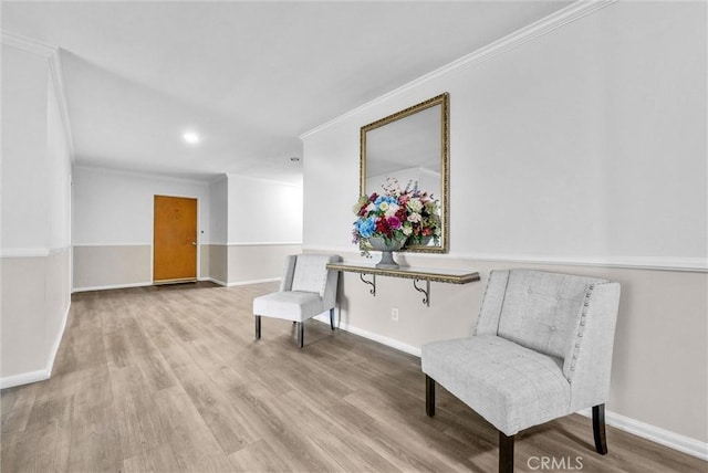 living area featuring baseboards, wood finished floors, and crown molding