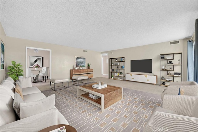 carpeted living room featuring a textured ceiling