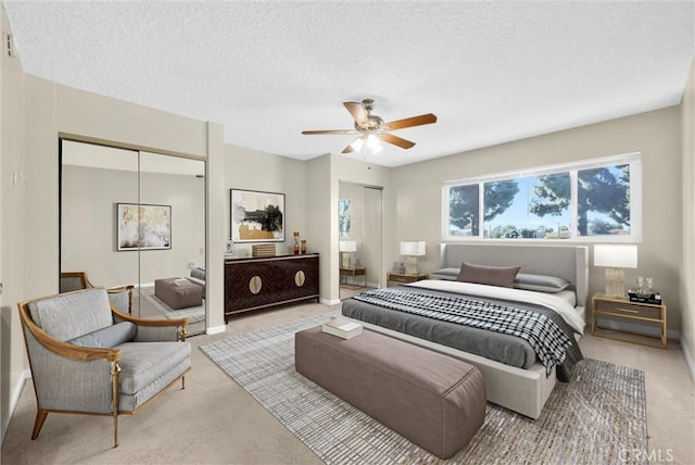 carpeted bedroom with a textured ceiling and ceiling fan