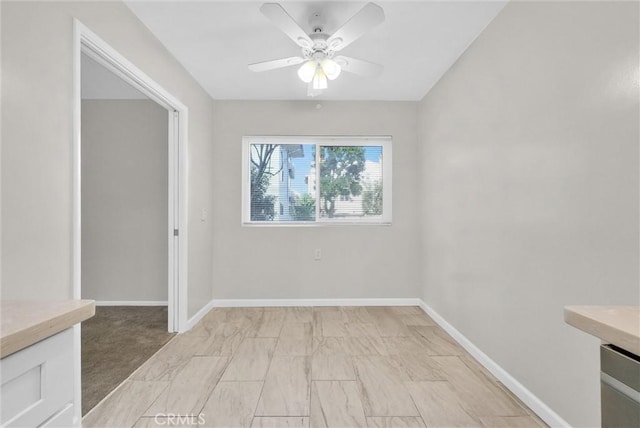 empty room with ceiling fan and baseboards