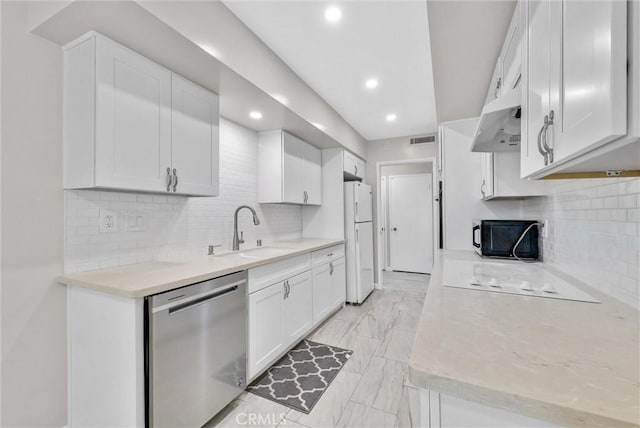 kitchen featuring a sink, white cabinetry, light countertops, stainless steel dishwasher, and freestanding refrigerator