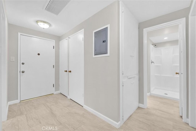 foyer entrance featuring baseboards, visible vents, and electric panel