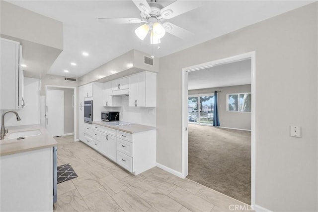 kitchen with visible vents, appliances with stainless steel finishes, light countertops, white cabinetry, and a sink